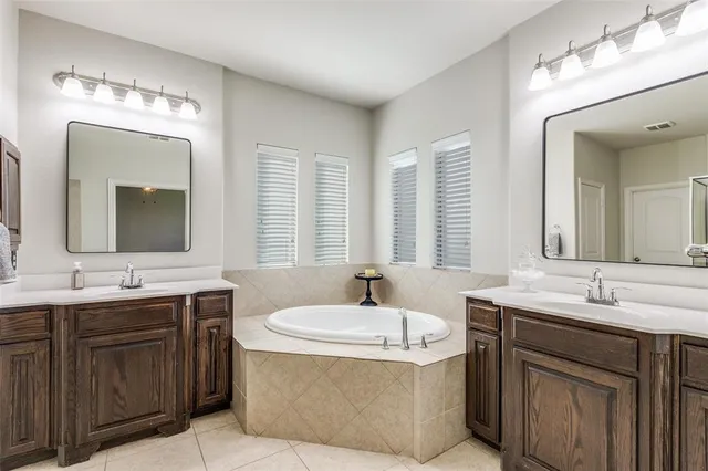 a bathroom with double vanity and a mirror