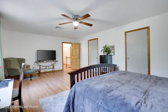 a bedroom with a bed and wooden floor