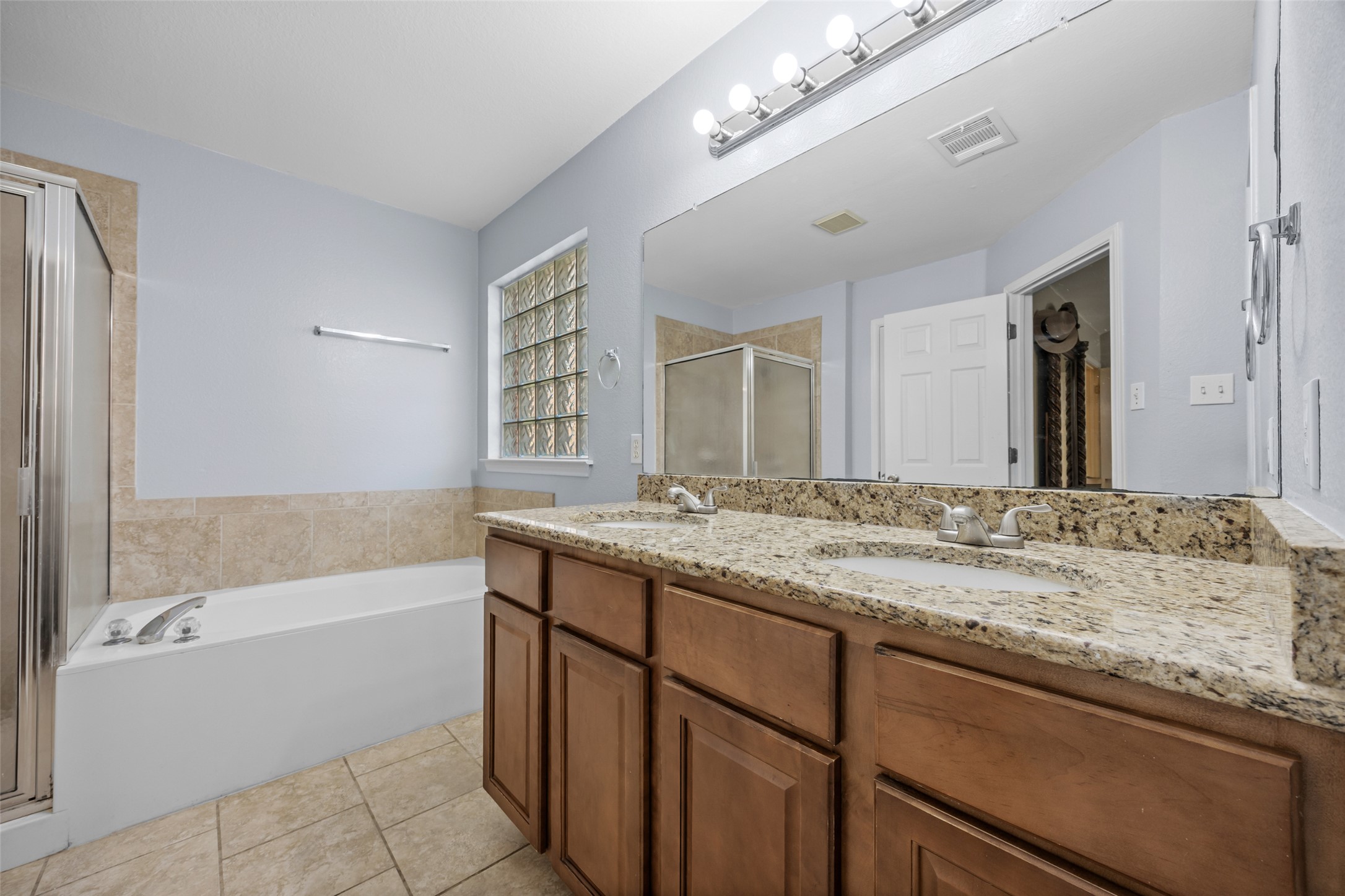 15918 Two Rivers Cove Austin, TX 78717 - Photo 19 of 30 Renovated primary bathroom with granite and modern fixtures.