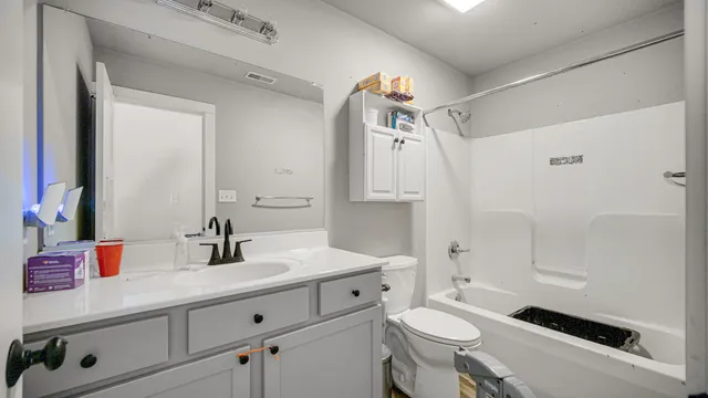 a bathroom with a double vanity sink toilet and shower