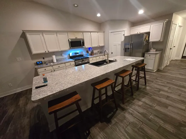 a kitchen with kitchen island a wooden floor and white appliances
