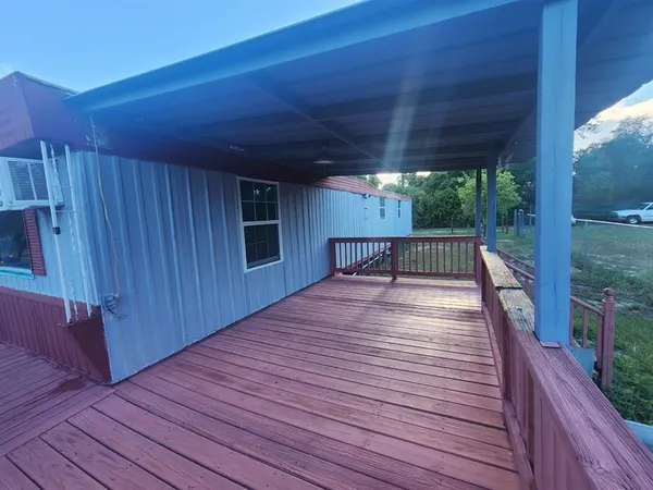 a view of backyard with a deck and wooden floor