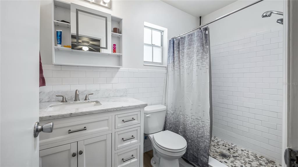 16317 Andrews Circle Cedar Key, FL 32625 - Photo 25 of 53 a bathroom with a granite countertop sink toilet and shower