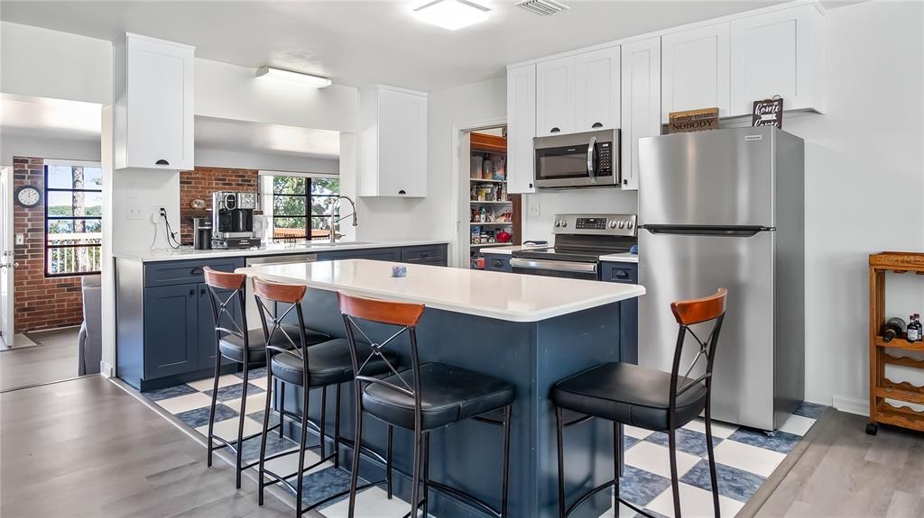 16317 Andrews Circle Cedar Key, FL 32625 - Photo 7 of 53 a kitchen with stainless steel appliances granite countertop a dining table chairs refrigerator and sink