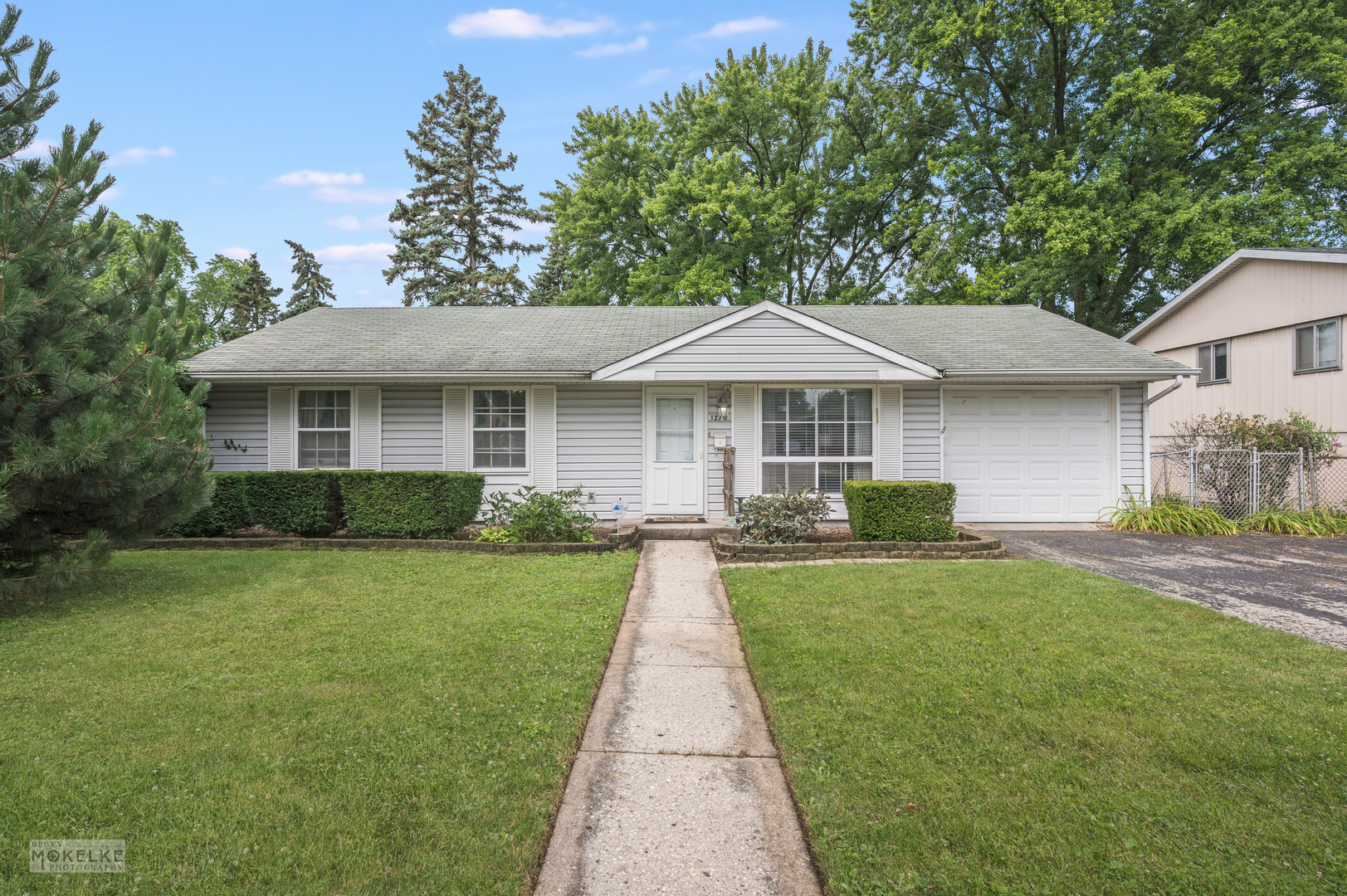 a front view of a house with yard patio and green space