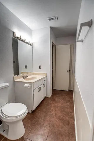 a bathroom with a double vanity sink mirror and toilet
