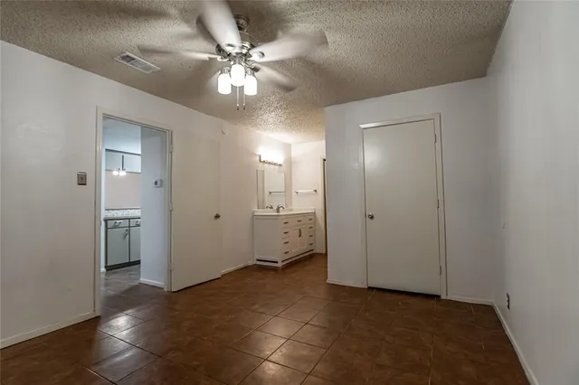 a view of a livingroom with a chandelier fan and windows