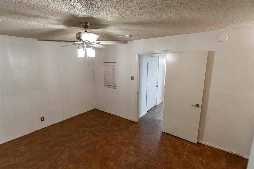 3327 Fallmeadow Street Denton, TX 76207 - Photo 28 of 31 an empty room with chandelier fan and closet area