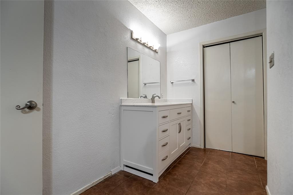 3327 Fallmeadow Street Denton, TX 76207 - Photo 29 of 31 a bathroom with a sink a mirror and a shower