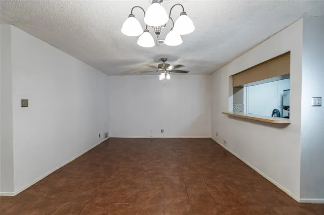 a view of a room with a hanging light and ceiling fan
