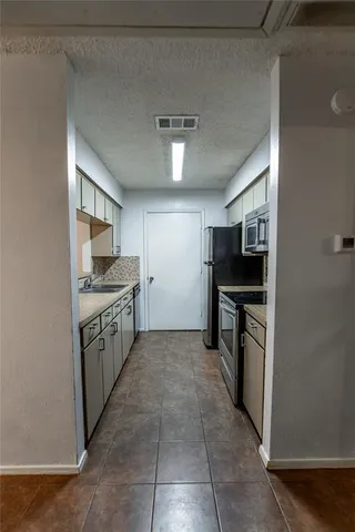 a kitchen with stainless steel appliances granite countertop a refrigerator and a stove