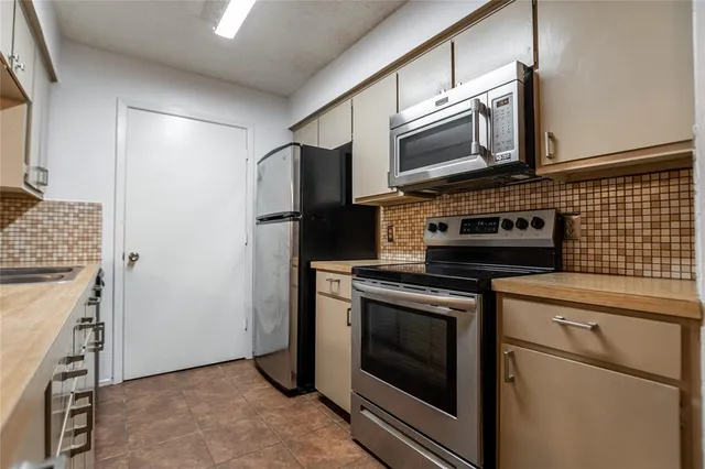 a kitchen with stainless steel appliances a stove microwave and sink