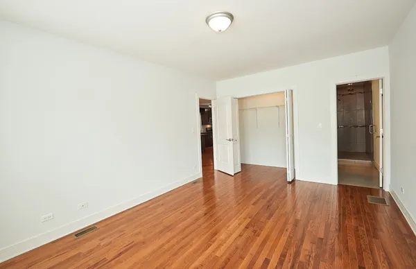 an empty room with wooden floor and closet