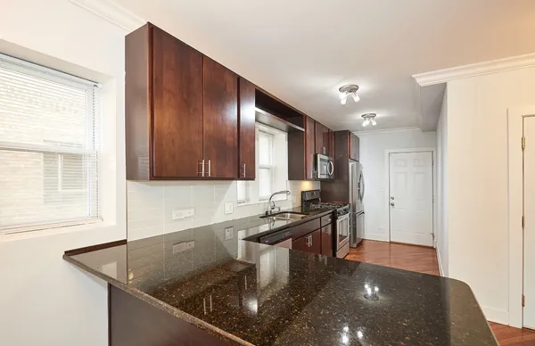 a kitchen with stainless steel appliances granite countertop a sink a stove and a microwave