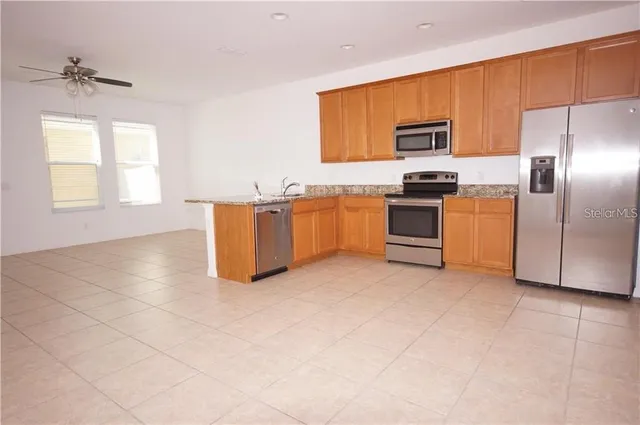 a kitchen with stainless steel appliances granite countertop a stove top oven a sink a counter top space and cabinets