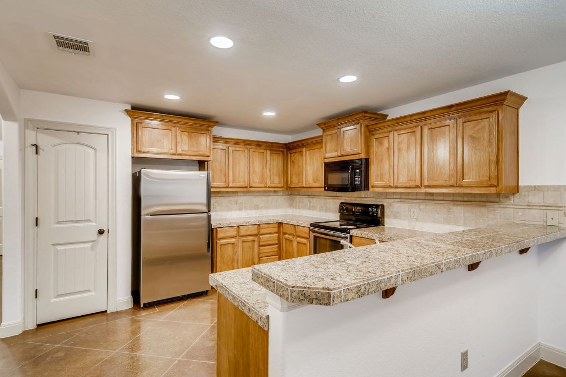 300 Venture Boulevard South Point Venture, TX 78645 - Photo 2 of 14 a kitchen with stainless steel appliances granite countertop a refrigerator stove top oven a sink and dishwasher