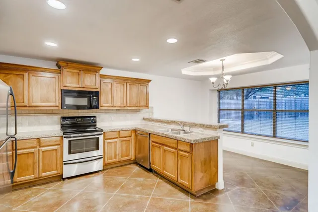 a kitchen with stainless steel appliances granite countertop a stove a sink and a refrigerator