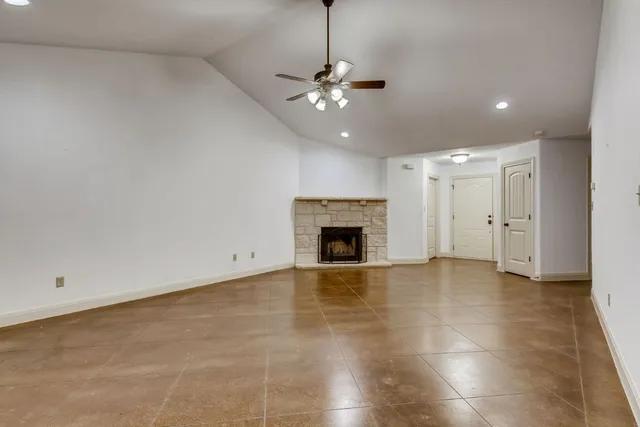 a view of a livingroom with a ceiling fan a fireplace and entryway
