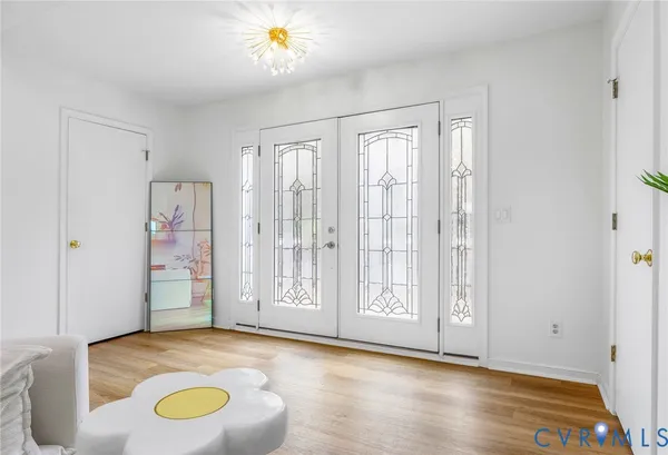 a view of an empty room with window and wooden floor
