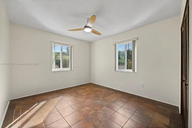 an empty room with closet and a ceiling fan