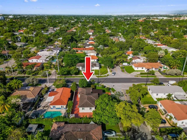 an aerial view of residential houses with outdoor space and trees