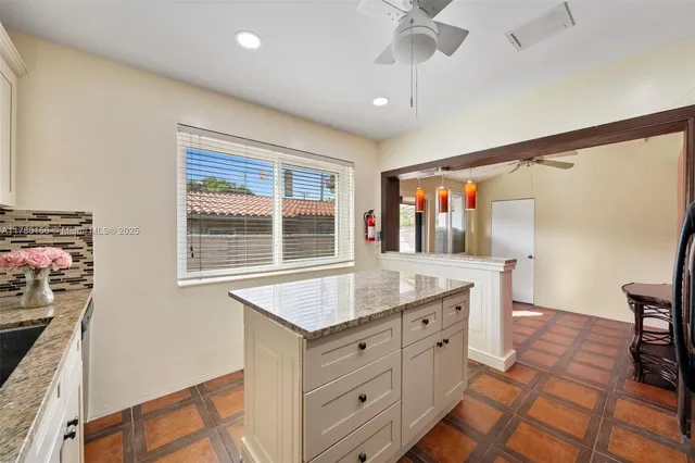 a kitchen with cabinets a counter space a sink and a window