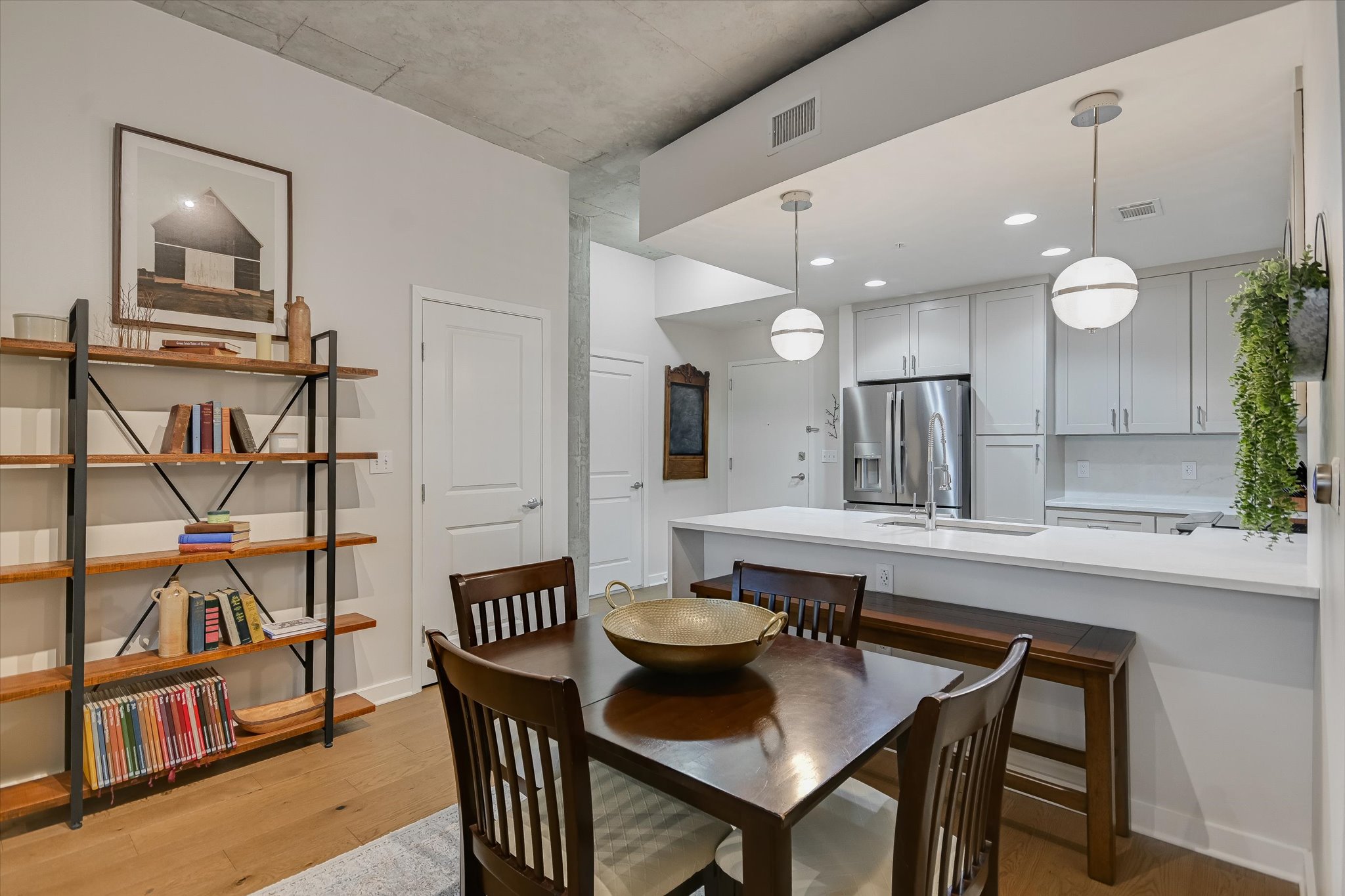 360 Nueces Street, Unit 1405 Austin, TX 78701 - Photo 14 of 40 a kitchen with stainless steel appliances kitchen island granite countertop a dining table chairs and a refrigerator