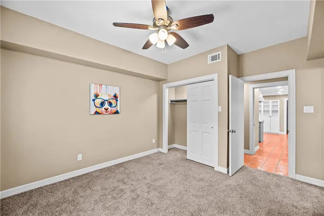 an empty room with closet and a chandelier fan