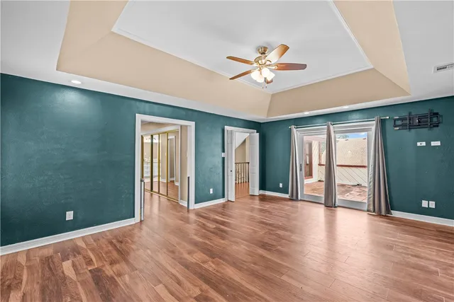 a view of a livingroom with a chandelier fan and windows