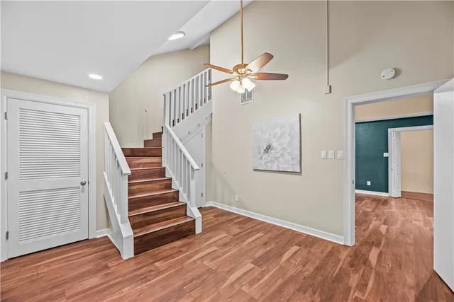 a view of a hallway with wooden floor and stairs