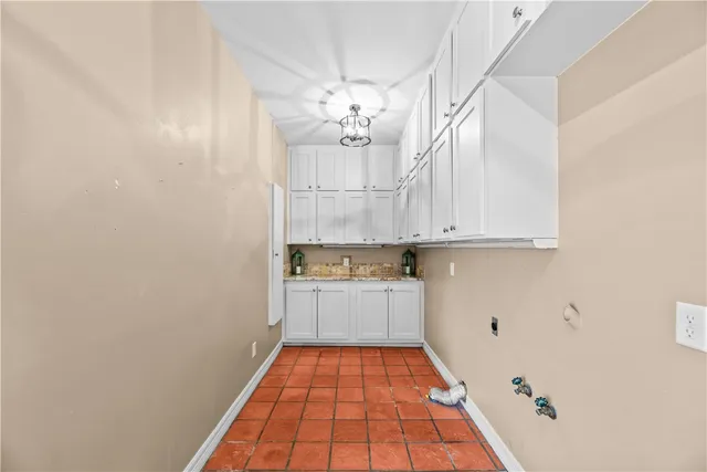 a room with granite countertop white cabinets and stainless steel appliances