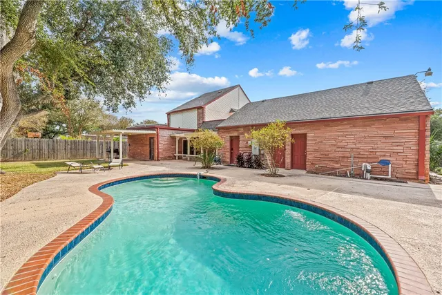 a swimming pool with outdoor seating and yard