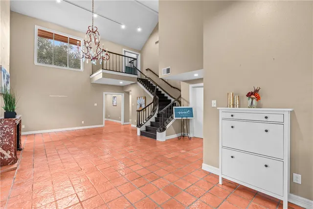 a view of hallway with stairs and chandelier