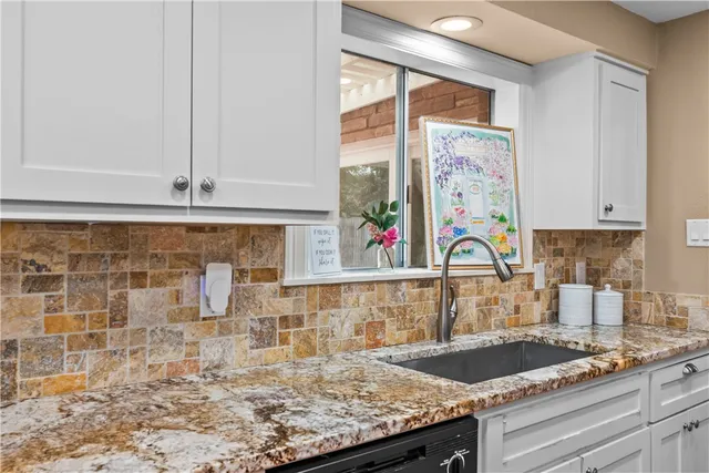 a kitchen with granite countertop a sink and a window