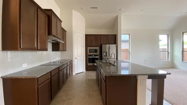 a kitchen with stainless steel appliances granite countertop a lot of counter space and wooden floor