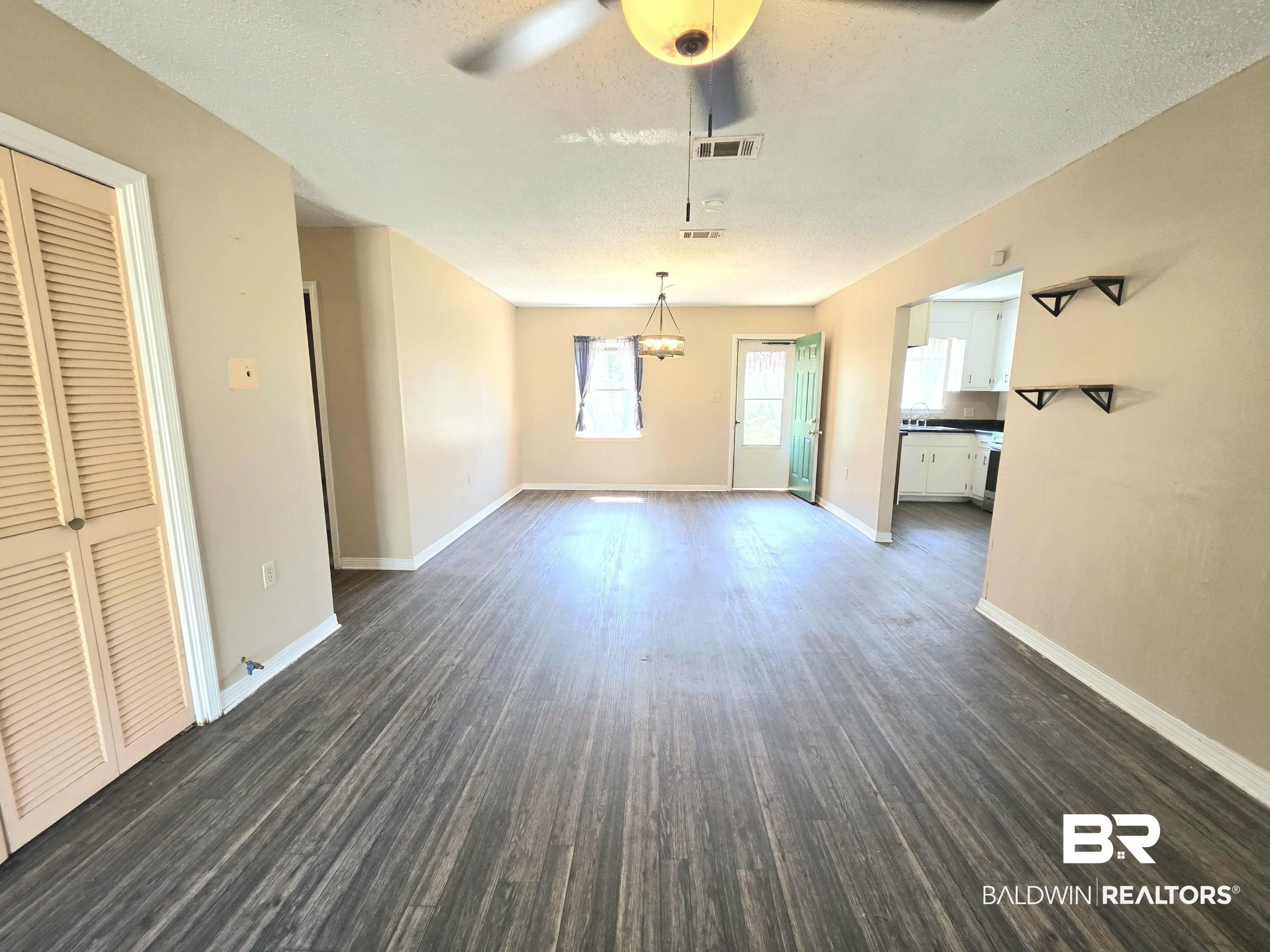11 Coal Fire Road Jackson, AL 36545 - Photo 15 of 23 Unfurnished dining area featuring a ceiling fan, a textured ceiling, and dark wood-style flooring