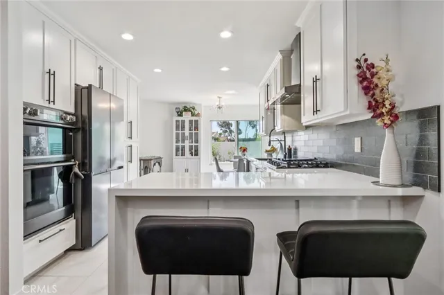 a kitchen with stainless steel appliances a sink stove and refrigerator