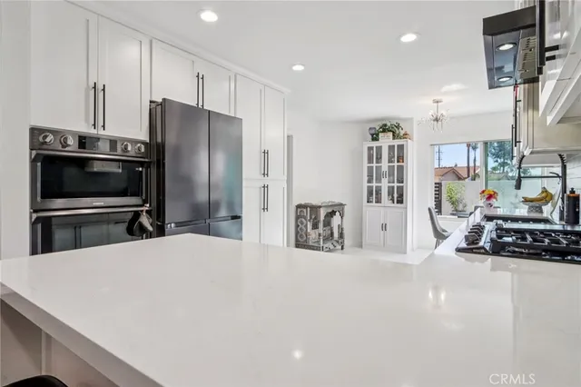 a kitchen with stainless steel appliances a refrigerator and a stove top oven