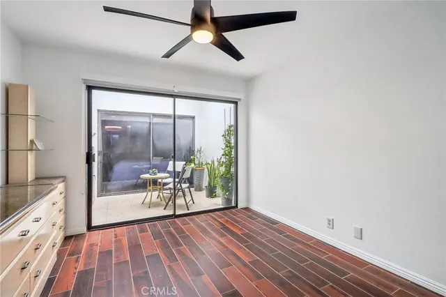 a view of a room with wooden floor and a ceiling fan