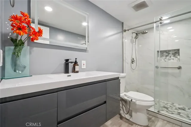 a bathroom with a sink a toilet and shower