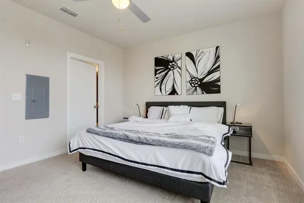 a bedroom with a bed and painting on the wall