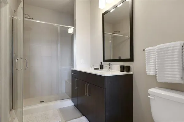 a bathroom with a shower sink and mirror