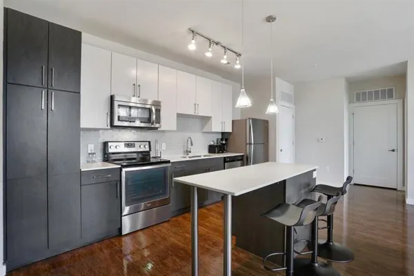 a kitchen with stainless steel appliances a stove a sink a microwave a refrigerator and cabinets