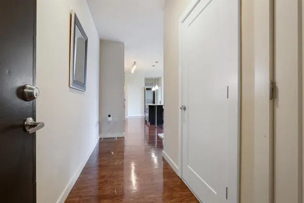 a view of a hallway with wooden floor and staircase