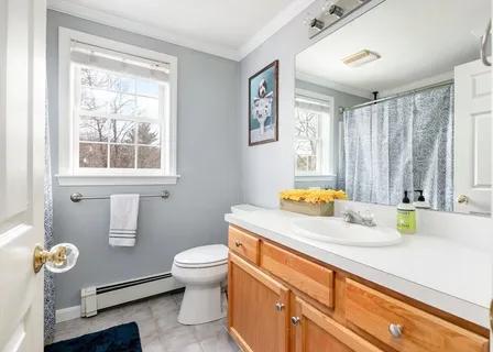 a bathroom with a sink a toilet and a window