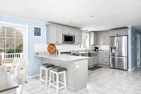a kitchen with a refrigerator and a stove top oven