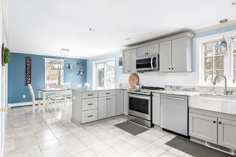 a kitchen with cabinets stainless steel appliances and a window