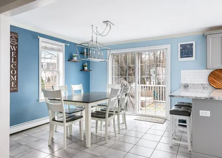 a dining room with furniture and a floor to ceiling window
