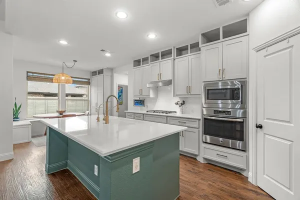 a large kitchen with stainless steel appliances granite countertop a large counter top a stove and a refrigerator
