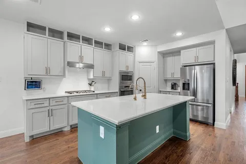 a kitchen with a sink stainless steel appliances and white cabinets